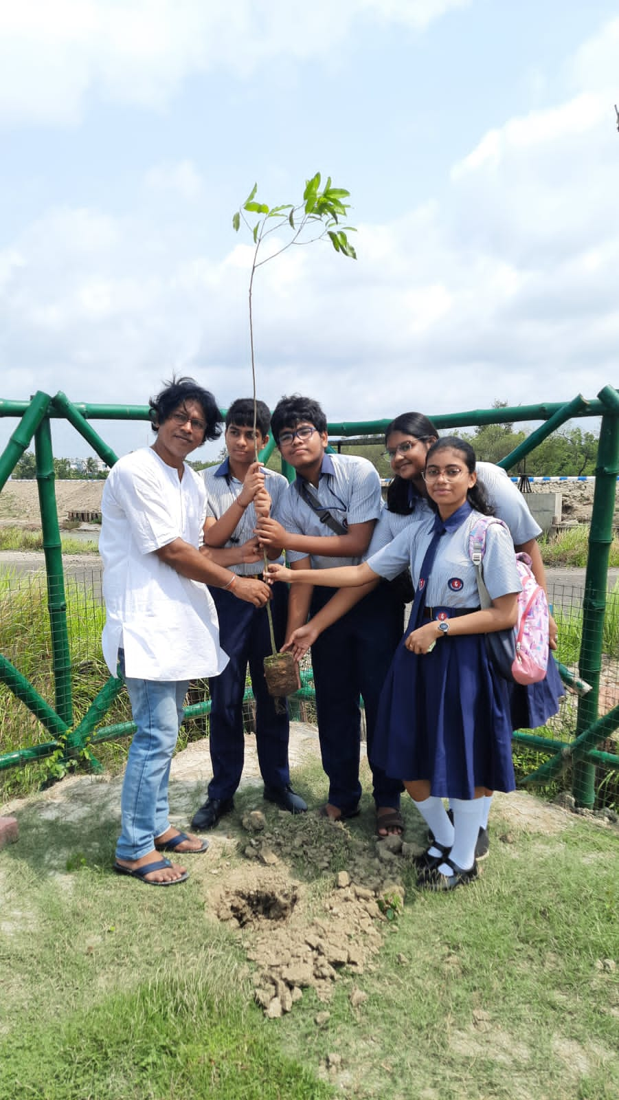 Students planting sapling